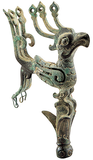 Bronze bird perched on bud of mythical tree