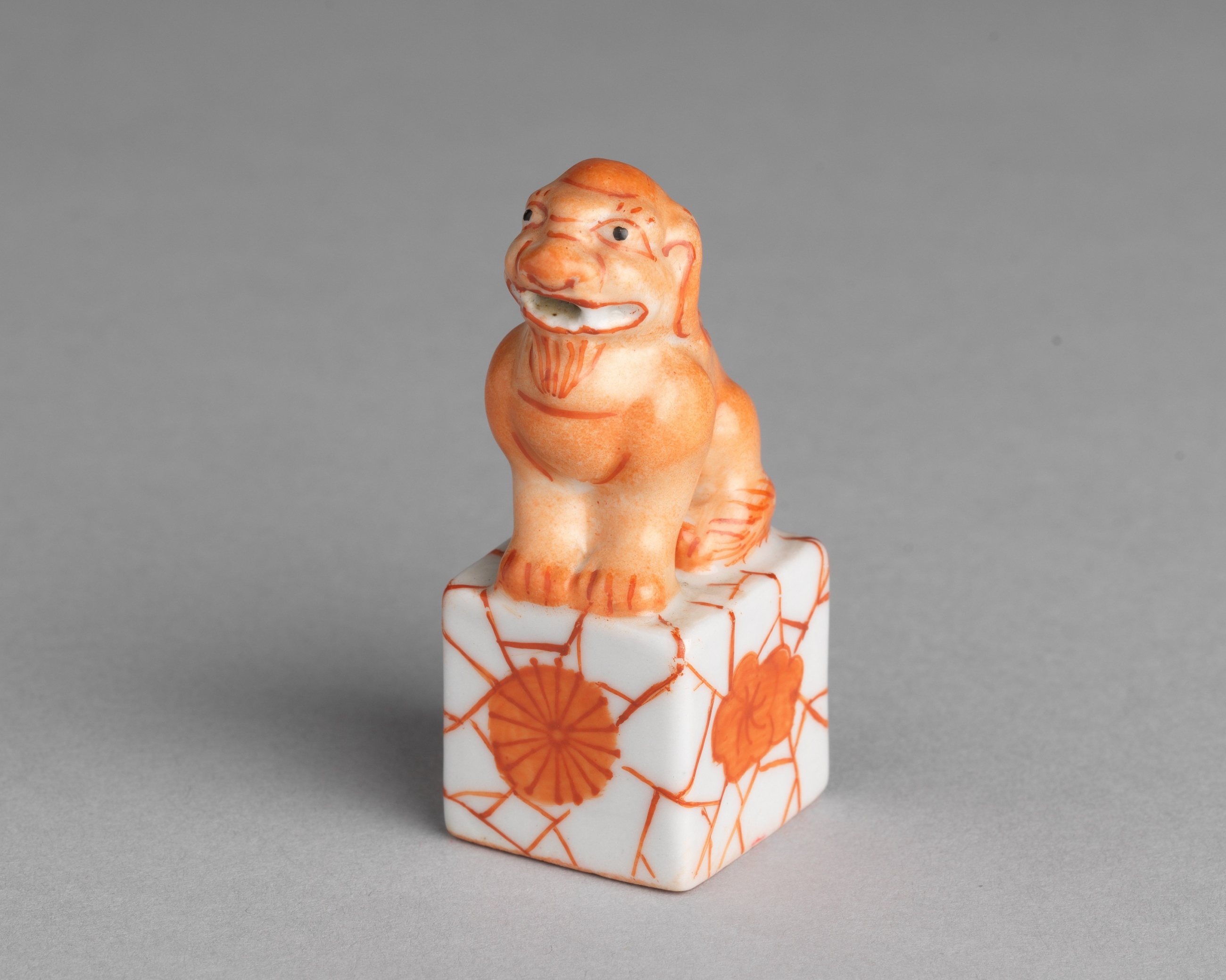 Porcelain seal with coral-red crackle decorations in the shape of a seated lion
