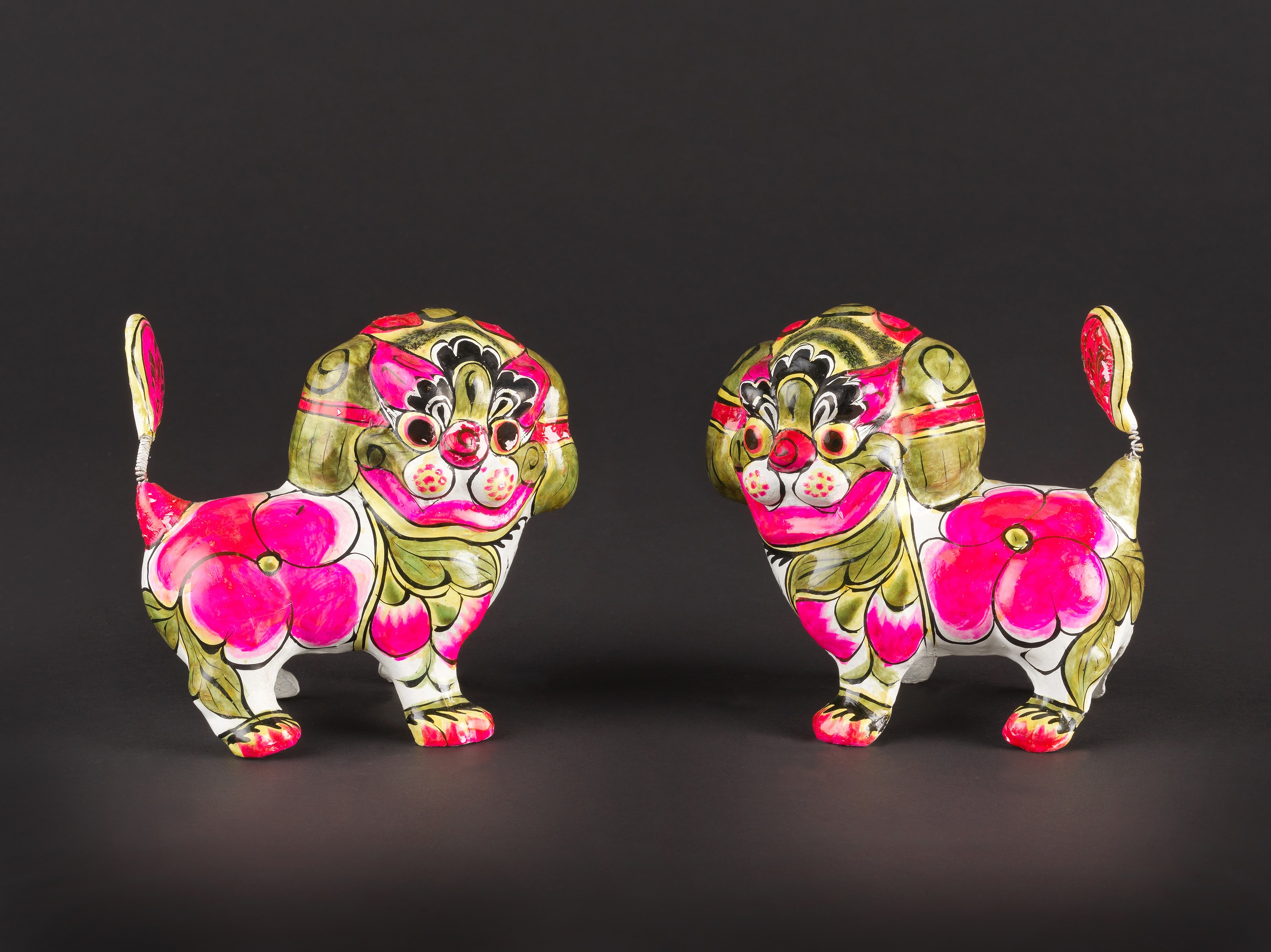 A pair of painted seating tigers in clay